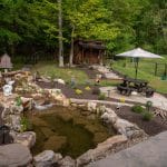 pond with mountain boulders and landscaping and flagstone patio with outdoor living space