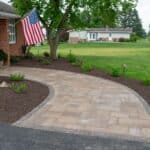 outdoor lighting in mulch bed with plantings with paver side walk
