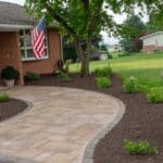 outdoor lighting in mulch bed with plantings with paver side walk