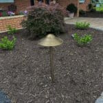 outdoor lighting in mulch bed with plantings