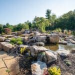 flagstone patio with outdoor living space featuring a fire pit and water feature with water falls