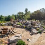 flagstone patio with outdoor living space featuring a fire pit and water feature with water falls
