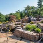 flagstone patio with outdoor living space featuring a fire pit and water feature with water falls
