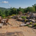 flagstone patio with outdoor living space featuring a fire pit and water feature with water falls