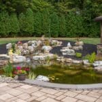 Outdoor living space with patio, pavilion, pond, and landscaping