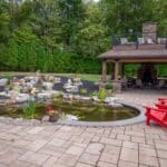 Outdoor living space with patio, pavilion, pond, and landscaping