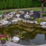 Outdoor living space with patio, pavilion, pond, and landscaping
