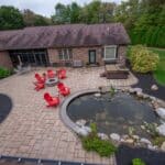Outdoor living space with patio, pavilion, pond, and landscaping
