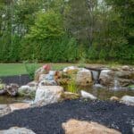 Outdoor living space with patio, pavilion, pond, and landscaping