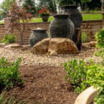 mulch planting bed with flagstone walk way and water feature with stacked slate urn waterfall
