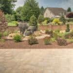 mulch planting bed with flagstone walk way and water feature with stacked slate urn waterfall