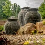 stacked slate urn water feature with mountain boulders and landscaping