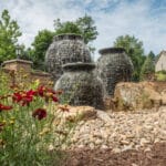 stacked slate urn water feature with mountain boulders and landscaping