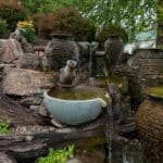 water feature with waterfall, mountain boulders, and landscaping