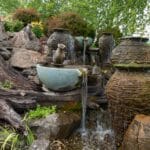 water feature with waterfall, mountain boulders, and landscaping