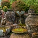 water feature with waterfall, mountain boulders, and landscaping