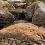 water feature with pond and mountain stream with boulders