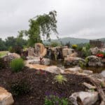 waterfall with koi pond, mountain , boulders, fire pit, flagstone patio and landscaping