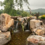 waterfall with koi pond, mountain boulders, and landscaping