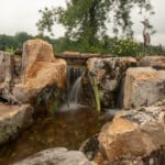 waterfall with koi pond, mountain boulders, and landscaping