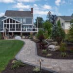 outdoor living space with paver patio, firepit, natural stepping stones, mulch planting beds, and landscaping