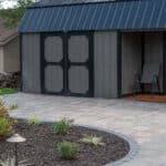 wide paver side walk with landscaping and outdoor lighting
