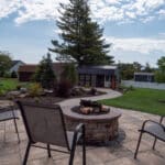 outdoor living space with paver patio, firepit, natural stepping stones, mulch planting beds, and landscaping