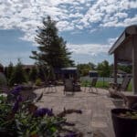 outdoor living space with paver patio, firepit, natural stepping stones, mulch planting beds, and landscaping