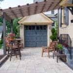 paver driveway with pergola and landscaping
