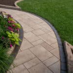 paver sidewalk with pergola and landscaping and edging