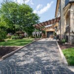 paver sidewalk with pergola and landscaping and edging fish scale driveway