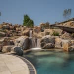 waterfall into rec swim pond with waterslide and paver patio
