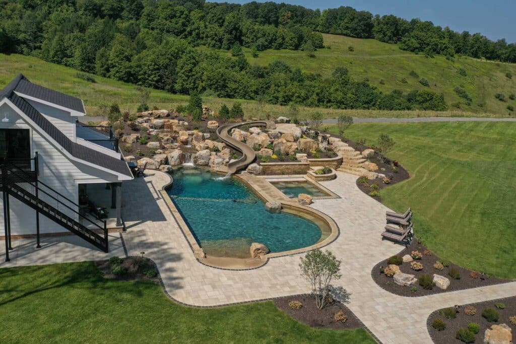 Outdoor living space with swim rec pond, paver patio, and landscaping