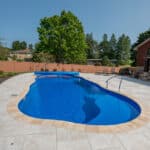 fiberglass swimming pool with paver patio