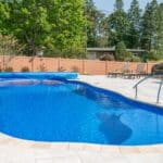 fiberglass swimming pool with paver patio
