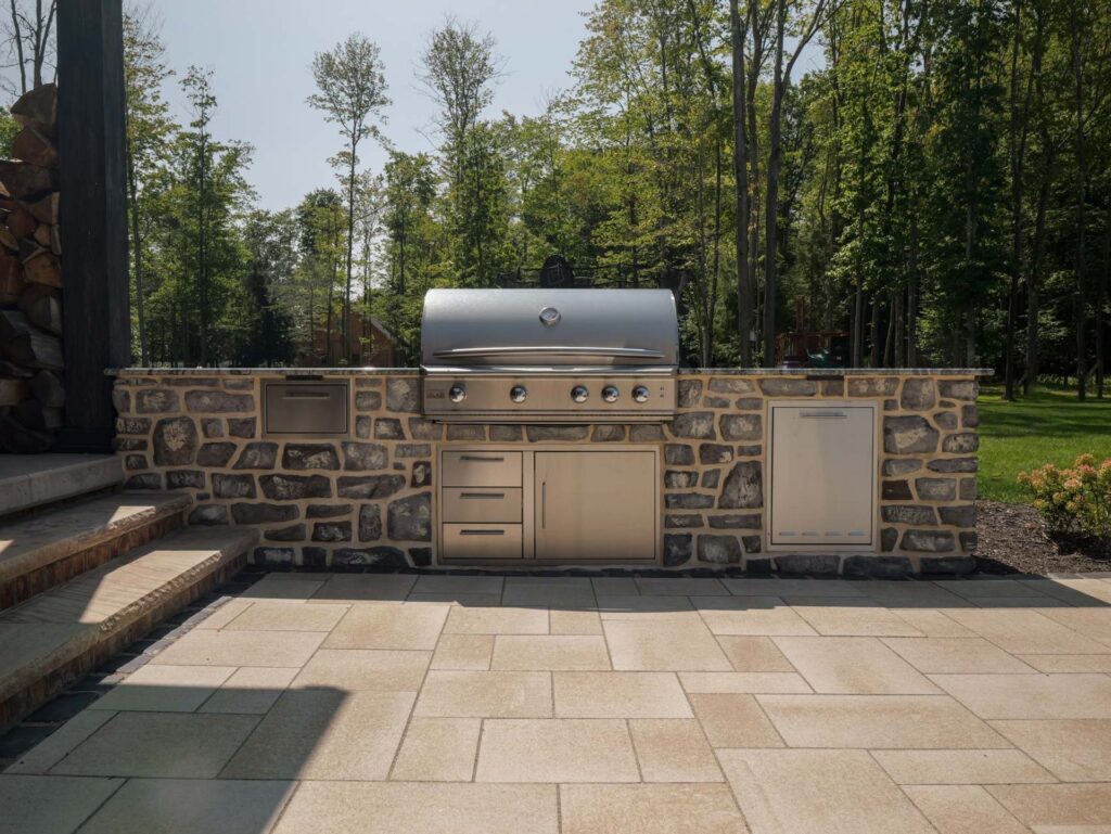 Outdoor living space with swim rec pond, outdoor kitchen, waterfall, and hot tub in Mahaffey, PA