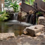 pond with waterfall and landscaping and mountain boulders