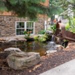 pond with waterfall and landscaping and mountain boulders