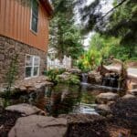 pond with waterfall and landscaping and mountain boulders