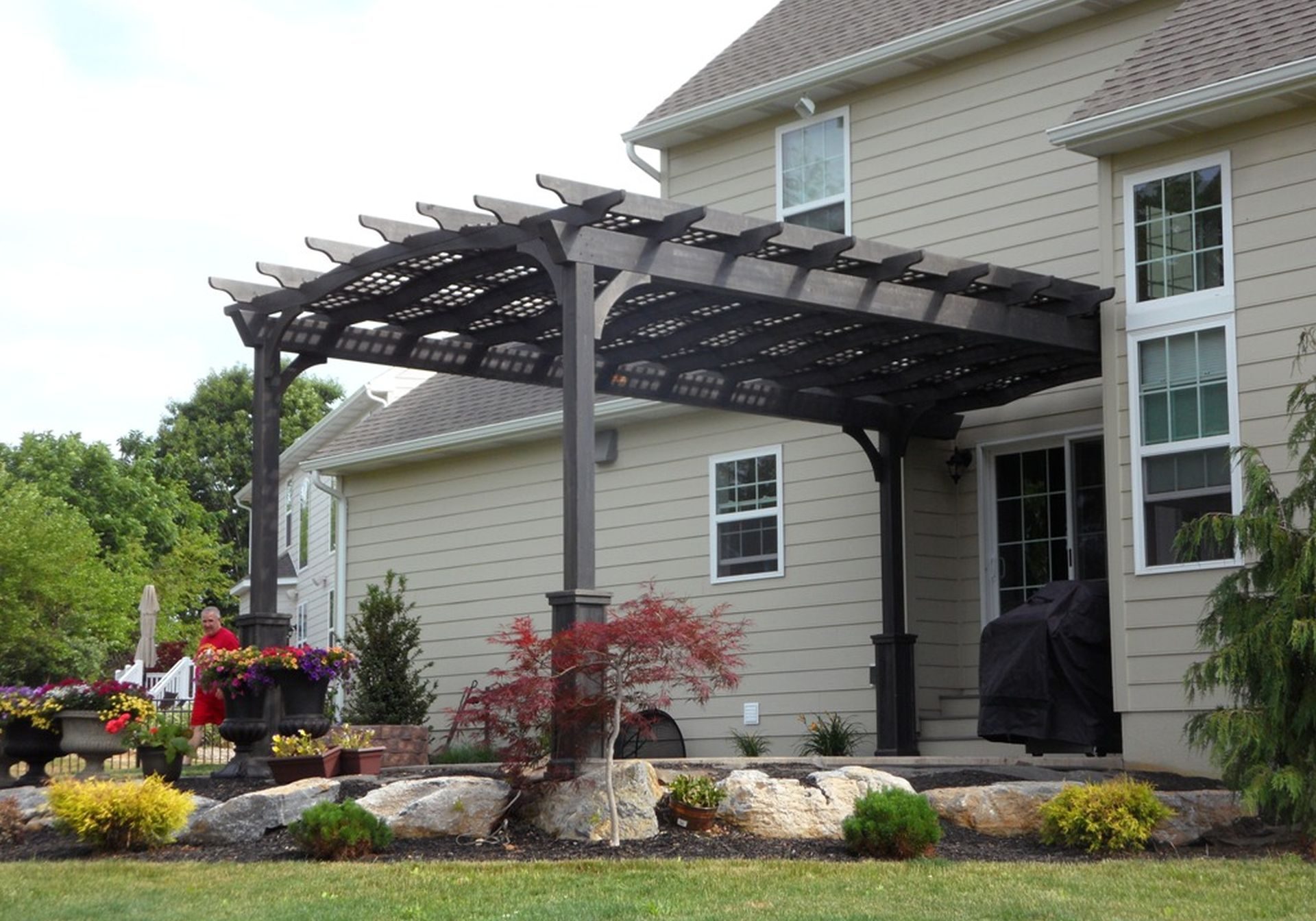 A black pergola in front of a house.
