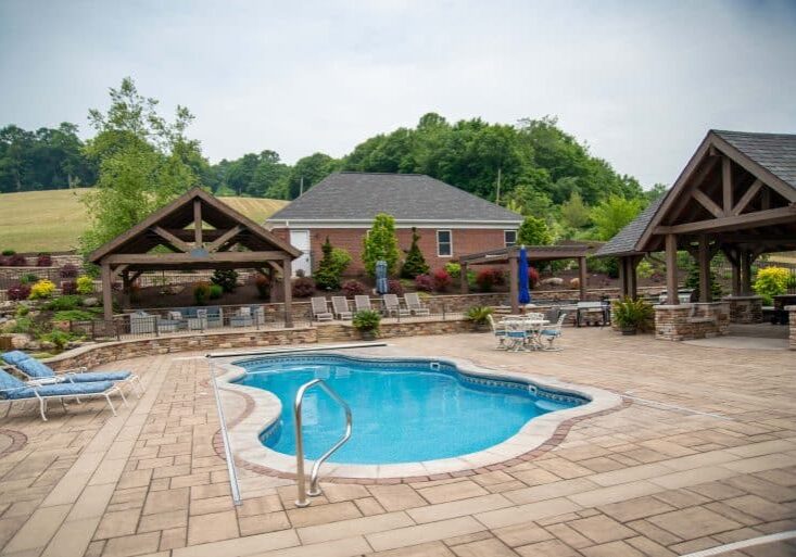 outdoor living space with pool, patio, pergola, pavilion, hot tub, pond