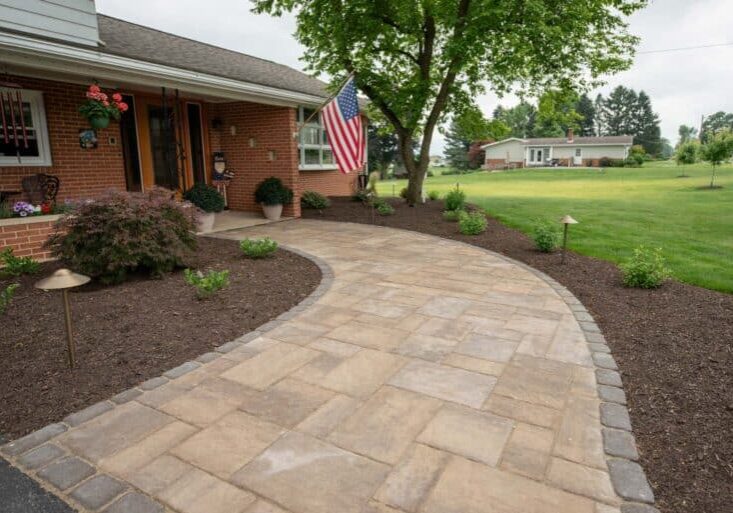 outdoor lighting in mulch bed with plantings with paver side walk