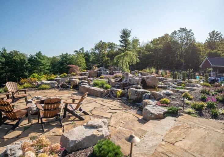 flagstone patio with outdoor living space featuring a fire pit and water feature with water falls