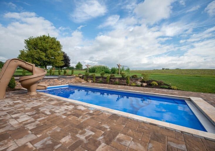 fiberglass swimming pool with paver patio