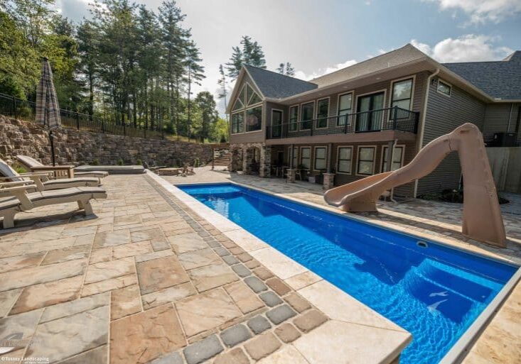 Outdoor living space with fiberglass swimming pool, paver patio, and outdoor swimming pool