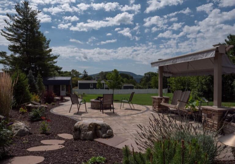 outdoor living space with paver patio, firepit, natural stepping stones, mulch planting beds, and landscaping