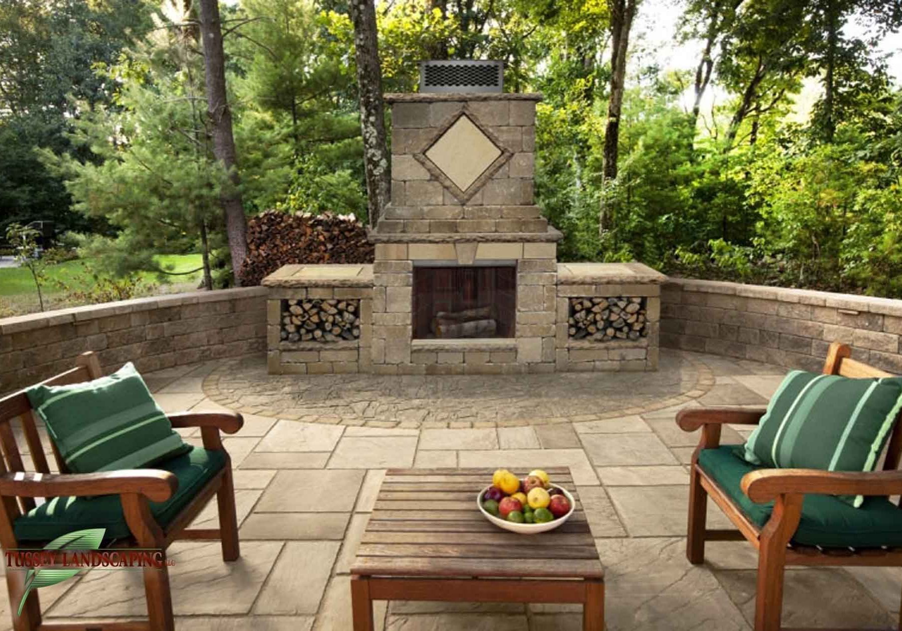 A patio with a fireplace and chairs.