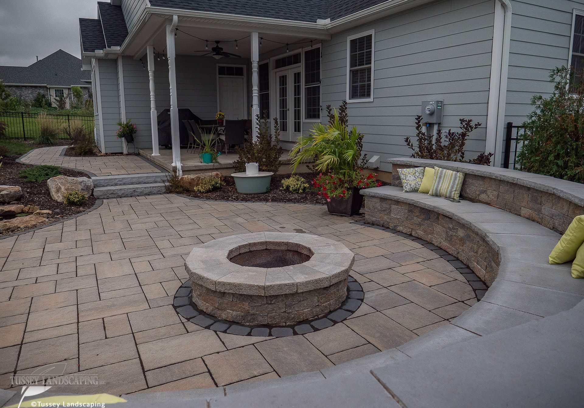 A patio with a fire pit and seating area.