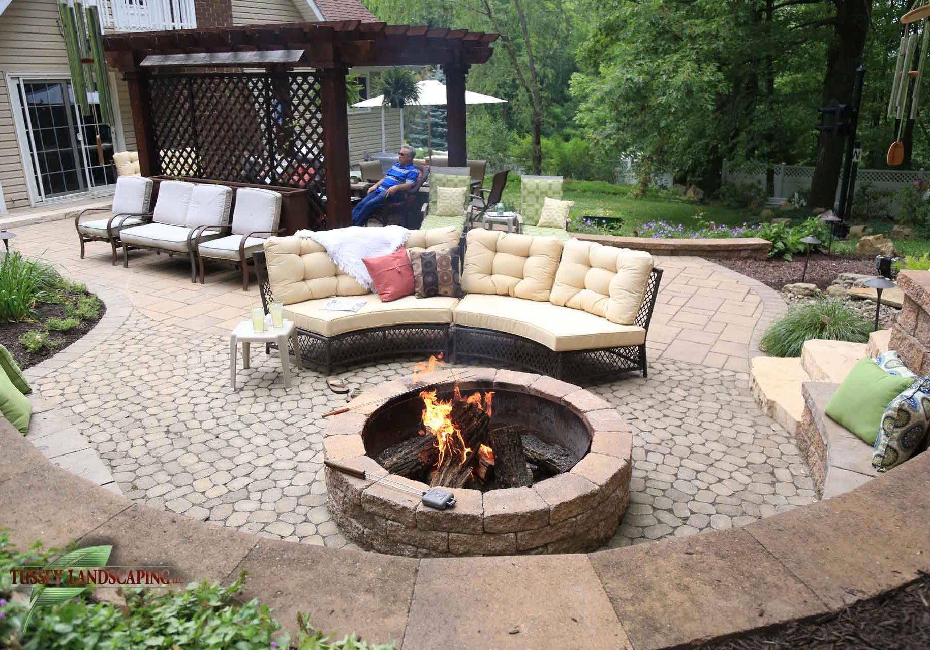 A backyard with a fire pit and patio furniture.