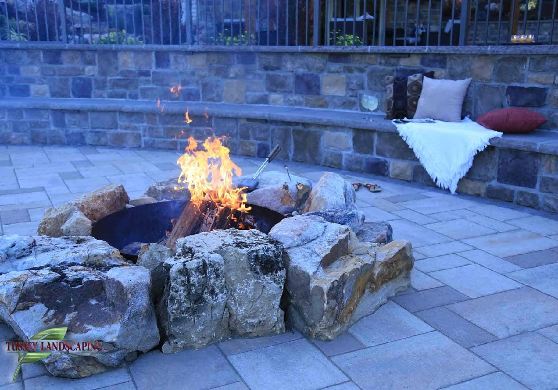 A fire pit is sitting on a stone patio.